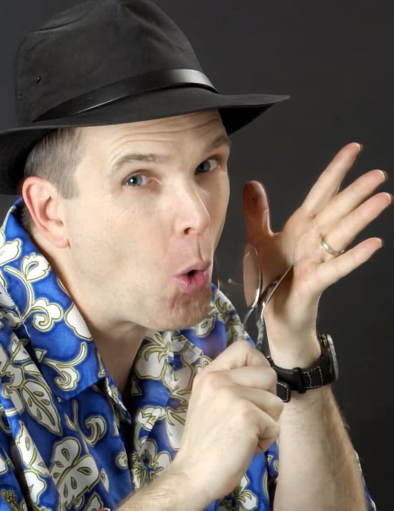 A photo of Jim Cruise, the Spoon Man holding a spoon as a microphone.